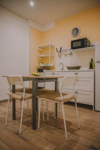 - une cuisine avec une table, 2 chaises et un évier dans l'établissement Dimora Giuditta, à Brindisi