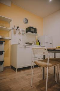eine Küche mit einem Tisch und einer Mikrowelle an der Wand in der Unterkunft Dimora Giuditta in Brindisi