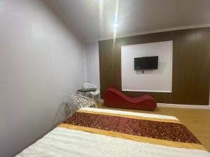 a bedroom with a bed and a tv on a wall at Motel Happy House- Hảo in Bạc Liêu