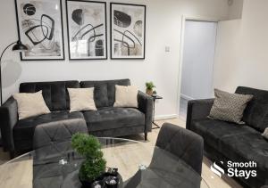 sala de estar con sofá negro y mesa de cristal en Contractors & Families 4 Bed House Sleeps 8, en Preston