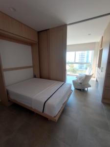 Salguero suites resorts في Gaira: غرفة نوم فيها سرير وكرسي