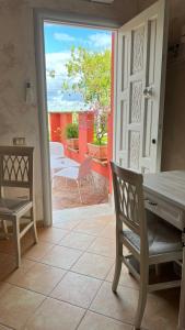 a door to a patio with a table and chairs at Borgo di Santa Barbara in Santa Domenica