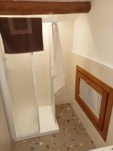 baño con cabina de ducha de cristal y lámpara en Bevi e Dormi, en Monteforte dʼAlpone