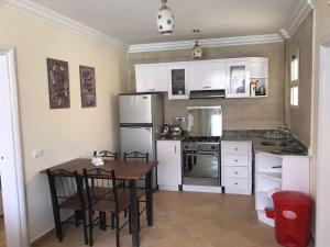 a kitchen with white appliances and a table and chairs at Serra Resort-Napa- Great Area in Sharm El Sheikh