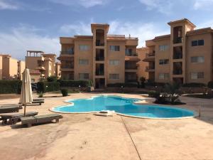 una piscina frente a un gran edificio de apartamentos en Serra Resort-Napa- Great Area en Sharm El Sheikh