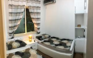 um pequeno quarto com uma cama e uma janela em Family Villa at Gjiri Lalzit em Durrës