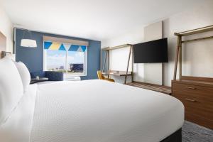 a bedroom with a large white bed and a window at Holiday Inn Express Las Vegas Stadium Area by IHG in Las Vegas