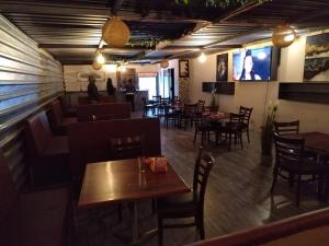 a restaurant with tables and chairs and a bar at NN Jacaranda Guesthouse in Newcastle