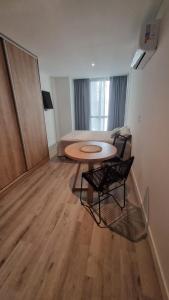 マル・デル・プラタにあるBrooklyn Suites MDPのテーブル、椅子、ベッドが備わる客室です。 +6枚の写真