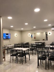 a dining room with tables and chairs and a screen at HOTEL 3 DE ABRIL in Mar del Plata