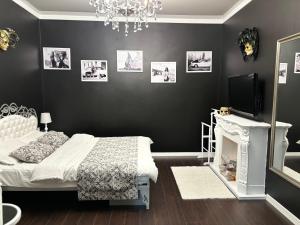 リヴィウにあるApartment Blue Dreamsの黒い壁のベッドルーム1室(ベッド1台、テレビ付)