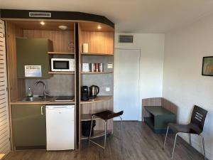 a small kitchen with a sink and a microwave at Studio chic le 808, paisible au porte de Paris Zenith et Villette! in Pantin