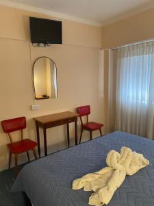 a bedroom with a bed and a table and chairs at HOTEL 3 DE ABRIL in Mar del Plata
