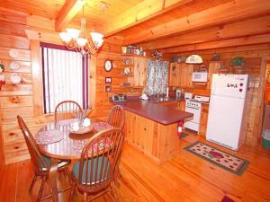 a kitchen with a table and chairs in a cabin at Mick's Hideaway - Semi-Secluded in Sevierville