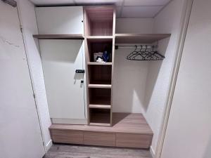 um quarto com um armário com prateleiras de madeira em 5 minutes de Paris - Studio Unique em Pantin
