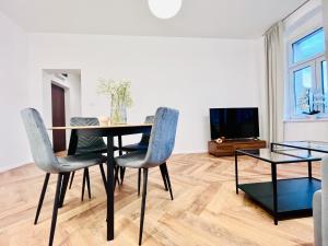 uma sala de jantar com mesa e cadeiras e uma televisão em Apartamenty Kamienica Centrum em Lubin