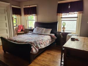 1 dormitorio con cama, escritorio y ventana en Scottwood Inn, en Toledo