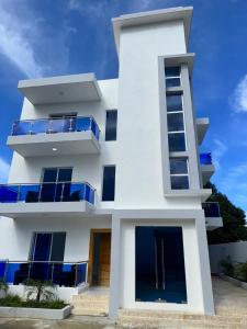 un edificio blanco con balcones azules en Luxury in Paradise 2, en San Felipe de Puerto Plata