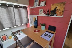 ein winziges Haus mit einem Tisch und einem Laptop darauf in der Unterkunft Bateau Le Chassane in Baume-les-Dames