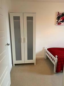 een slaapkamer met een bed en 2 glazen kasten bij Modern 3bed house in central location & free parking in Aberdeen