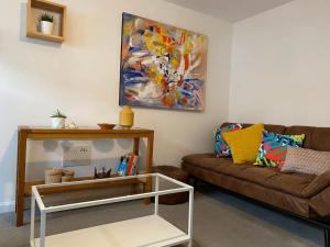 a living room with a couch and a painting on the wall at Modern 3bed house in central location & free parking in Aberdeen