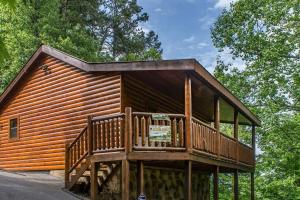 uma grande cabina de madeira com um grande deque em Holly Tree Hideaway - Semi Secluded Mtn Setting em Sevierville