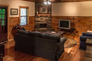sala de estar con sofá y TV en Holly Tree Hideaway - Semi Secluded Mtn Setting, en Sevierville