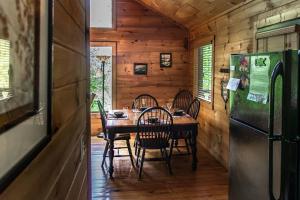 uma sala de jantar com uma mesa e um frigorífico em Holly Tree Hideaway - Semi Secluded Mtn Setting em Sevierville