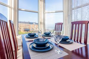 una mesa de comedor con platos y copas de vino en The Priory House, en Tynemouth