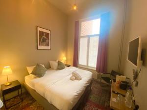 um quarto com uma cama e uma janela em Simone's Kitchen B&B em Antuérpia