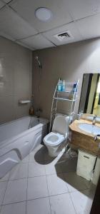a bathroom with a toilet and a bath tub and a sink at One BHK in Ajman 