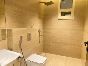 a bathroom with a toilet and a sink at Nuzul R157 - Elegant Apartment in Riyadh