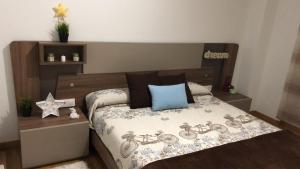1 dormitorio con 1 cama con cabecero de madera en APARTAMENTO MOAÑA - PLAYA A XUNQUEIRA, en Moaña