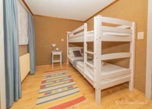 1 dormitorio con 2 literas y alfombra en Hôtel l’escale en Le Châble