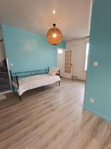 um quarto com uma cama e uma parede azul em sci ecs APPART em Ablon-sur-Seine