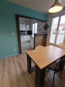 uma cozinha e sala de jantar com uma mesa de madeira em sci ecs APPART em Ablon-sur-Seine