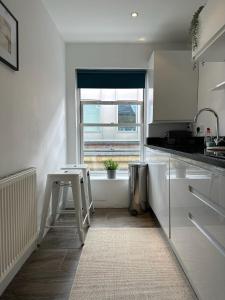 cocina blanca con mesa y ventana en Stylish One Bedroom Flat Chancery Lane, en Londres