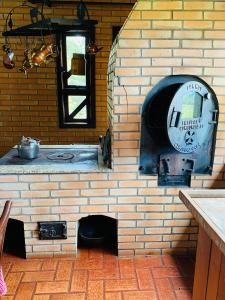 ceglana ściana z piekarnikiem na świeżym powietrzu w kuchni w obiekcie Casa de Campo w mieście Colônia Murici
