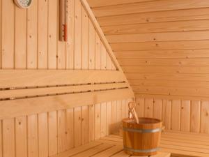 een houten sauna met een houten emmer erin bij Holiday home with whirlpool quiet area in Zeeland in Colijnsplaat