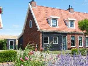 een stenen huis met een rood dak bij Holiday home with whirlpool quiet area in Zeeland in Colijnsplaat