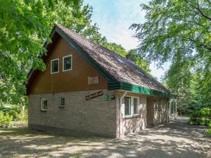 een klein bakstenen gebouw met een gambrel dak bij Beautiful home with lots of privacy, in the forest in De Bult