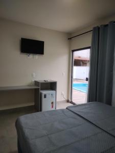 - une chambre avec un lit et une porte coulissante en verre dans l'établissement Morada Stucchi, à Balneário Camboriú