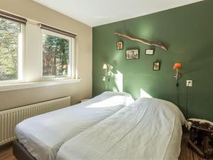 ein Schlafzimmer mit einem weißen Bett und einer grünen Wand in der Unterkunft Home with lots of privacy, in the forest in De Bult