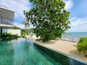 una piscina infinita con vistas al océano en Beachfront 3 Bedrooms - AMANA Villa at Ta-Ke Residence Phuket, en Phuket