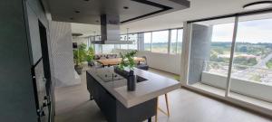 a kitchen and living room with a large window at Vive Alto Reñaca in Viña del Mar