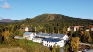 an aerial view of a building with a mountain in the background at Vandrarhemsboende på Ammarnäsgården in Ammarnäs