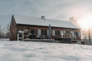 a brick house with snow on the ground in front of it at Villa ADurbuy avec Jacuzzi in Durbuy +31 photos