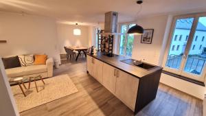 a kitchen and living room with a couch and a table at Ferienwohnung im ehemaligen Gesindehaus in Welschbillig