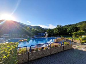 a large swimming pool with the sun in the background at Ferienwohnung im ehemaligen Gesindehaus in Welschbillig