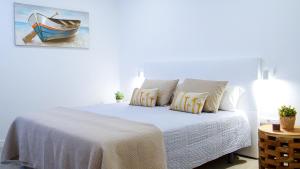 1 dormitorio con 1 cama y una pintura de un barco en Casa Lorenzo, en Puerto del Carmen